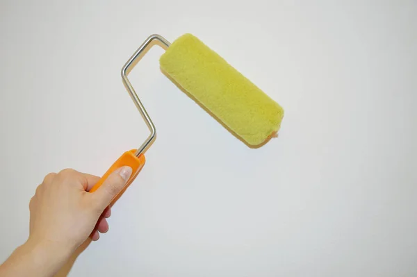 Mano Femenina Sostiene Rodillo Pintura Contra Fondo Pared Blanco — Foto de Stock