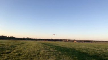 Quadrocopter yazın günbatımında tarlada uçar..