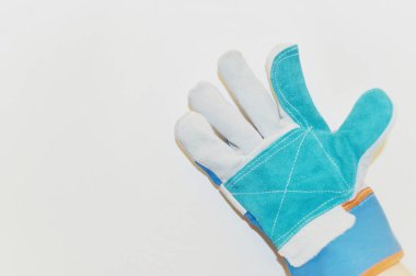 Beyaz duvar arkaplanına karşı mavi kumaş eldiven.
