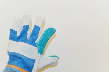Beyaz duvar arkaplanına karşı mavi kumaş eldiven.