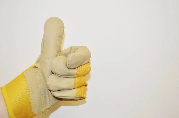 Hand Beige Und Gelb Arbeitstuchhandschuh Zeigt Zeichenklasse Vor Weißem Wandhintergrund — Stockfoto