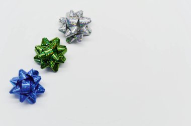 Kopya alanı olan beyaz bir arkaplanda hediyeler için üç parlak fiyonk seti.