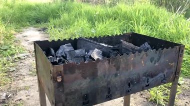 Ateşleme için yeşil otların arka planında metal bir pıhtıya sıvı dökülüyor..