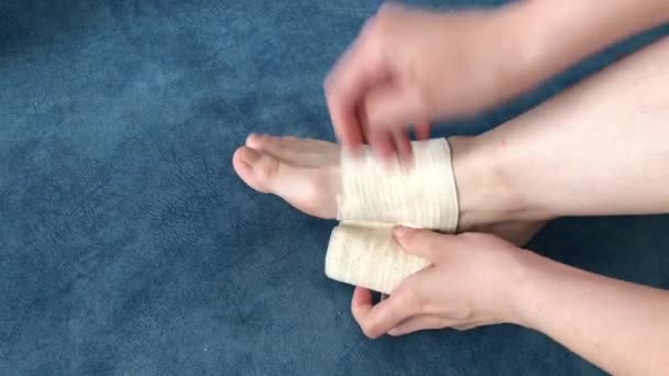 Νεαρή Γυναίκα Τυλίγει Πόδι Της Ελαστικό Επίδεσμο — Αρχείο Βίντεο