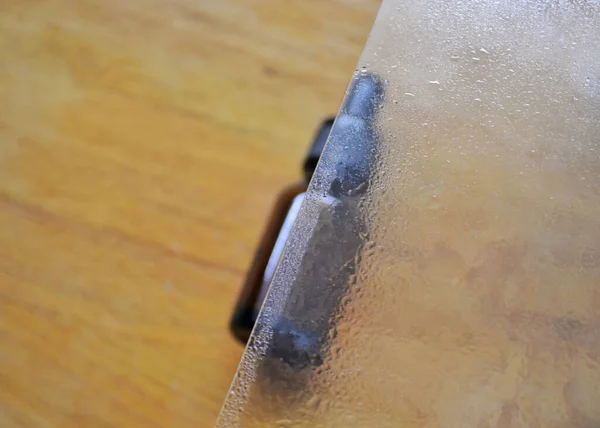 Garrafa de vidro marrom encontra-se em um fundo de madeira. Através de vidro transparente — Fotografia de Stock