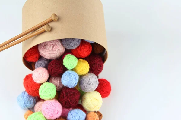 Bir sürü renkli, dağınık yün yün yumakları ve yuvarlak bir karton hediye kutusundan örgü iğneleri. El işi, dikiş ve dikiş konsepti. Flatlay. Kopyalama alanı.