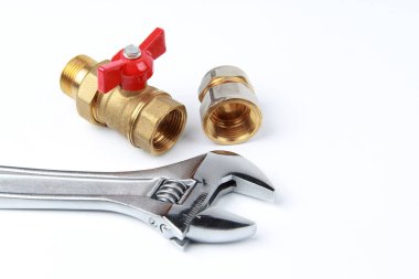 Yeni metal ayarlanabilir çelik anahtar ve beyaz arka planda adaptörü olan pirinç su musluğu. Tesisat ve gaz tesisatının onarımı ve bağlantısı. Kopyalama alanı.