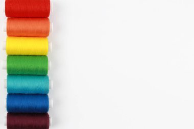 Renkli, iğneyle dikmek için gökkuşağı iplikleri. El yapımı konsept, giysi tamiri. Üst Manzara. Düz çizgi. Kopyalama alanı.