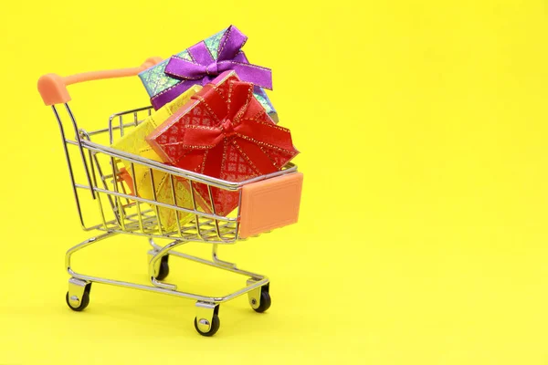 Gift Boxes Lie Shopping Basket Isolated Yellow Background Concept Holiday — Stock Photo, Image