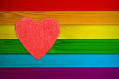 LGBT tabelasının gökkuşağı renkli tahtalarının ahşap dokulu arka planında kırmızı bir kalp bulunur. Gey ve lezbiyen topluluklarının gurur sınırı olarak kullanılabilir. Broşür tasarımı, tebrik kartları için.