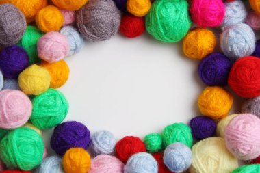 Örgü örmek için renkli iplik topları, ortasında yazı için boş bir alan. El yapımı konsept, evde çalışma, iplik satışı, kartpostal, kayıt şemaları. Üst görünüm. Kopyalama alanı.