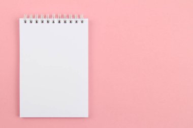 Pembe bir arka plan-eskiz defteri ya da satıra dökülmemiş bir defter. Boş bir düzen yaratıcılık, çizim, yazma planları, duyurular için bir alandır. Bir not yazmak önemlidir.