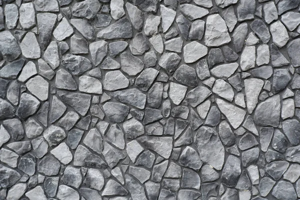 Taş bir duvarın siyah ve beyaz arkaplanı. Duvarlar, modern bir binanın dekorasyonu olarak beton ve taştan yapılmış. Eski bir taş duvarın arka planı..