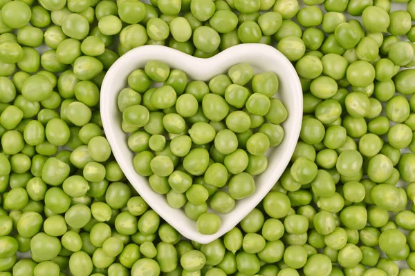 Pois Verts Sont Couchés Dans Une Assiette Blanche Forme Cœur — Photo