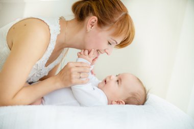 Odasında annesinin yanında mutlu bir çocuk var.