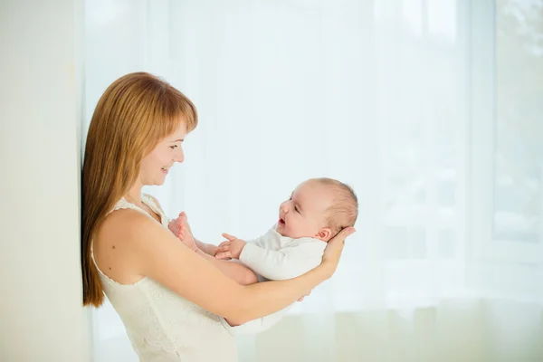 Mutter und Baby küssen und umarmen sich. Glückliche Familie Stockbild