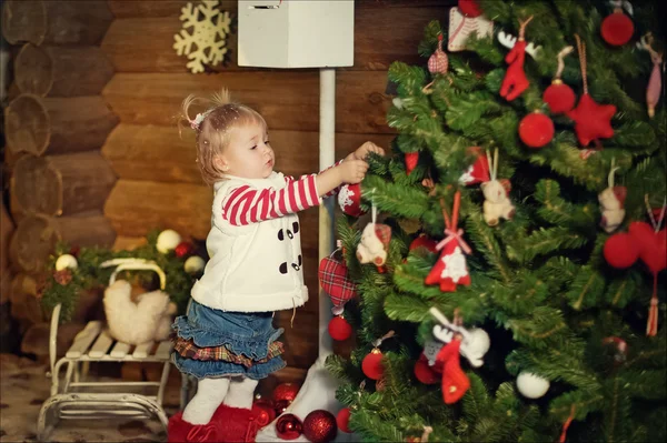 Klein meisje versiert de kerstboom — Stockfoto