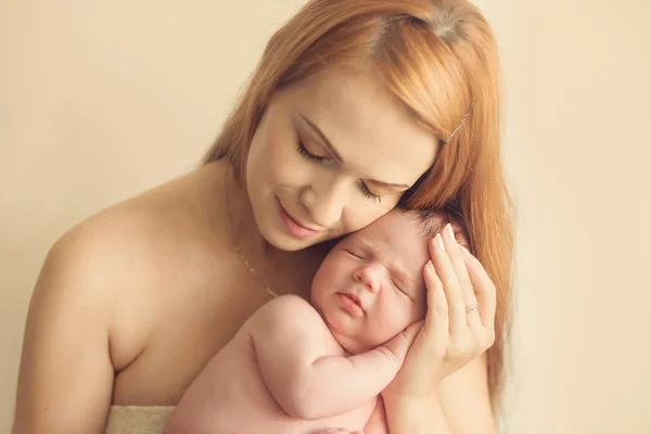 Young loving mother hugging her sleeping 10 days old baby — Stock Photo, Image