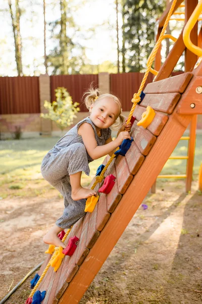 Piccola ragazza carina sta giocando sul parco giochi . — Foto Stock