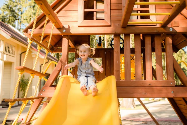 La bambina sorridente al parco giochi — Foto Stock