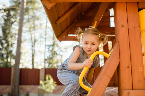 Carino bella sorridente bambina su un parco giochi — Foto Stock