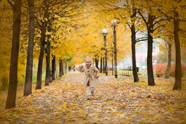 Happy children in autumn park. Kids juggle leaves — Stock Photo, Image