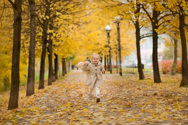 Happy child in autumn park. Kids juggle leaves — Stock Photo, Image