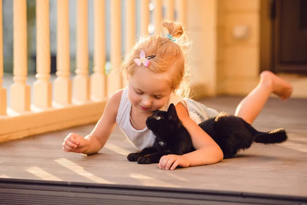 Kleines Mädchen umarmt eine Katze — Stockfoto