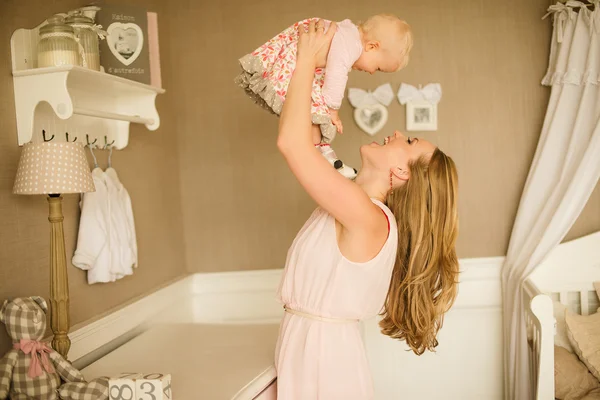 Happy family. Mother throws up and kissing baby — Stock Photo, Image