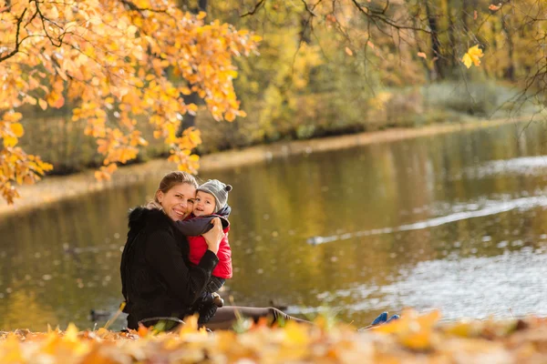 母と赤ちゃんの少年の秋に楽しんで — ストック写真