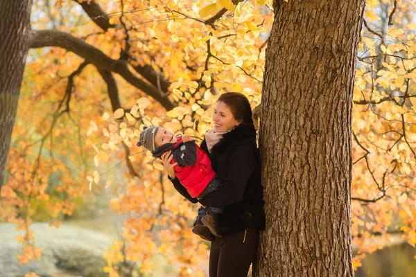 幸せな母と子秋の公園で楽しんで — ストック写真