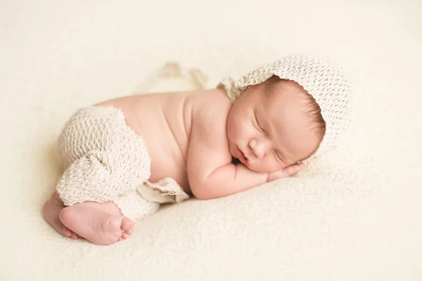 Εικόνα ενός νεογέννητου μωρού μέχρι τα κατσαρά αντίδια στον ύπνο σε μια κουβέρτα Royalty Free Φωτογραφίες Αρχείου