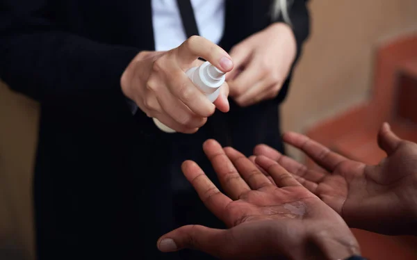 Close Up Of Businessman Having Hands Sprayed With Sanitiser During Health Pandemic