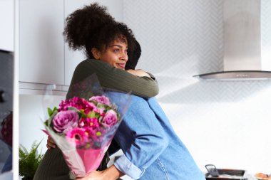 Sevgililer Günü 'nü kutlamak için evde bir sürü çiçekli erkek ve sürpriz bir kadınla romantik bir çift.