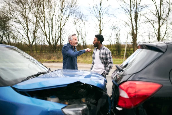 若い男性ドライバーと車の事故のための責任を主張積極的なシニア男性ドライバー — ストック写真