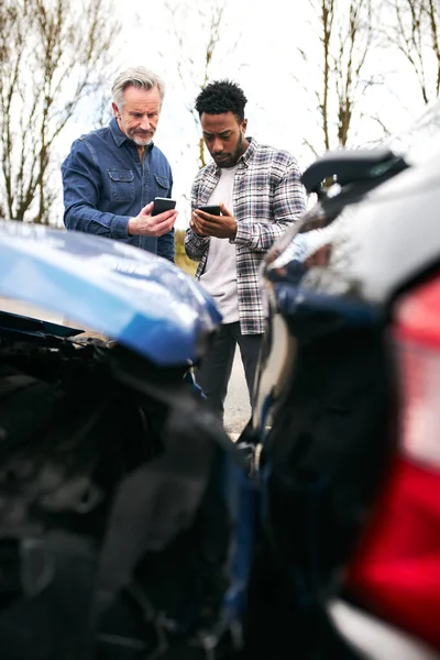 交通事故後の自動車保険の詳細を交換する道路の脇に2人の男性ドライバー — ストック写真
