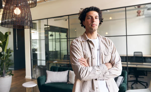 新しいビジネスの近代的なオープンプランオフィスに立って気軽に身を包んだ若い男の肖像画 — ストック写真