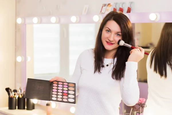 Joven maquilladora mujer sosteniendo cepillos — Foto de Stock