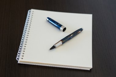 Ofis ahşap masasında boş not defteri.