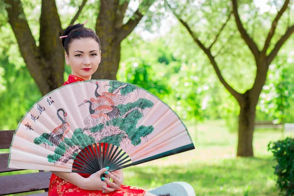 Joven asiática chica caminando en nacional vestido con un ventilador en la par —  Fotos de Stock