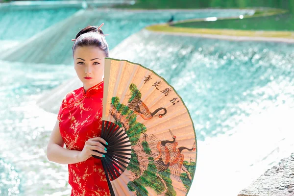 Joven asiática chica caminando en nacional vestido con un ventilador cerca de la r —  Fotos de Stock