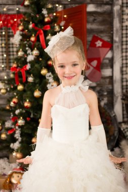 Sevimli genç güzel kız beyaz Noel elbiseli oturma