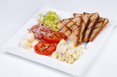 Geleneksel İngiliz kahvaltısı pişmiş yumurta, domates, patates, ekmek ve taze salata ile