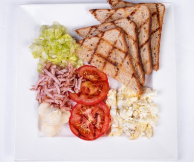 Geleneksel İngiliz kahvaltısı pişmiş yumurta, domates, patates, ekmek ve taze salata ile