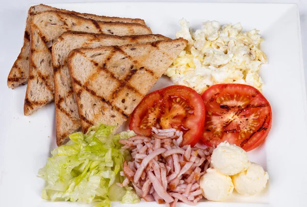 Geleneksel İngiliz kahvaltısı pişmiş yumurta, domates, patates, ekmek ve taze salata ile