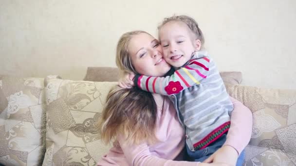 Küçük kız öpücük anne yanak, closeup manzaraya kanepe — Stok video