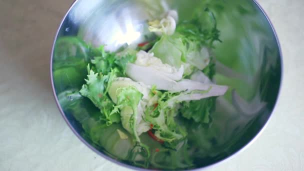 Mains féminines mettre des tranches de légumes dans le bol — Video