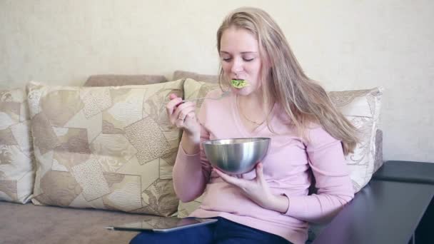 Leende ung kvinna med en forkful av sallad — Stockvideo