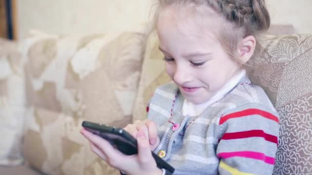 Closeup portrait child. Girl using mobile phone and smiling. — Stock Video