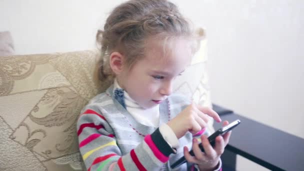 Closeup portret kind. Meisje met behulp van mobiele telefoon en glimlachen. — Stockvideo